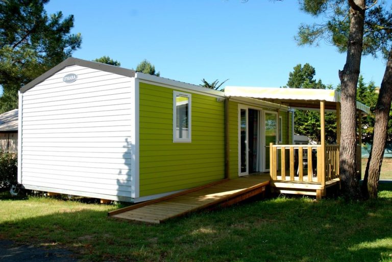 Mobil-home vert avec terrasse en bois