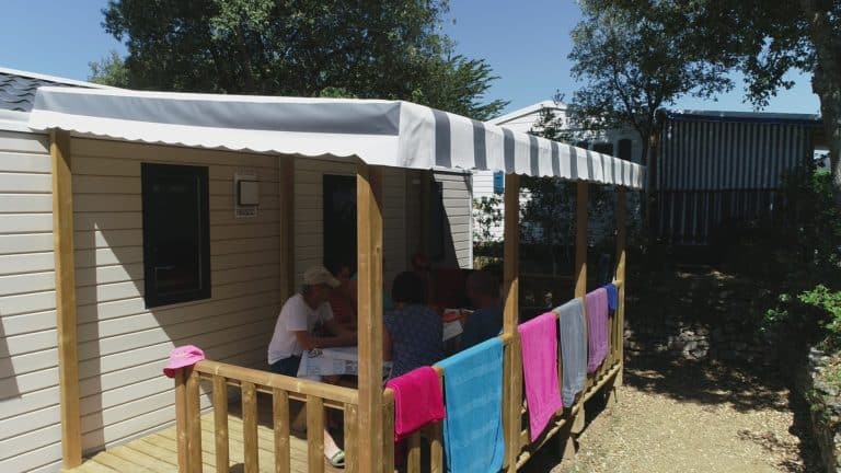 Famille profitant d'une terrasse ombragée au camping.
