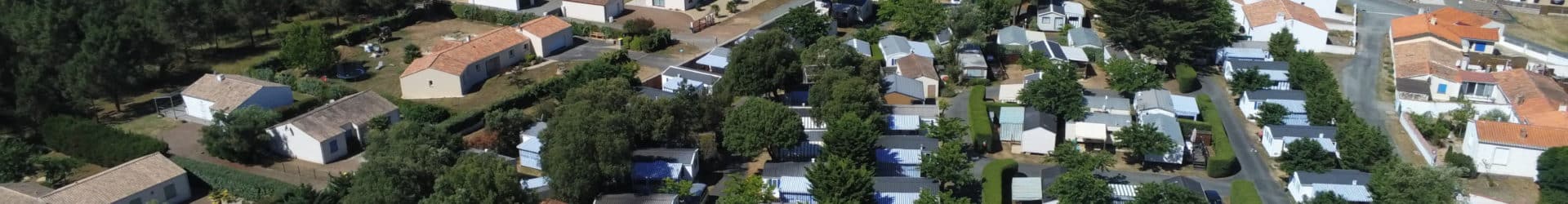 Vue aérienne du camping avec piscine et forêt.