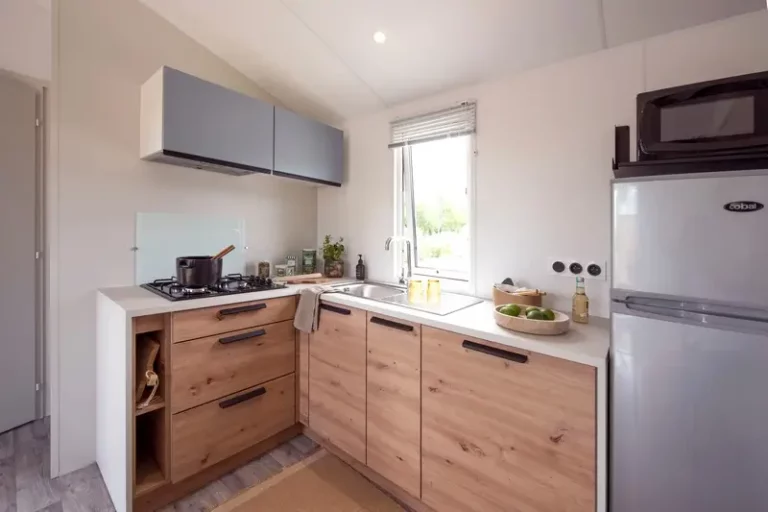 oin cuisine d'un mobil-home au camping La Frétille : plaques 4 feux, évier, micro-ondes et réfrigérateur-congélateur